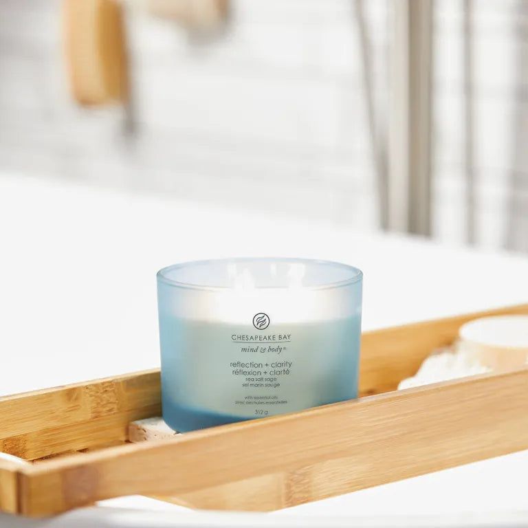 Bougie bleue Chesapeake Bay, mind & body, reflection + clarity, sur plateau en bois. Contexte salle de bain.