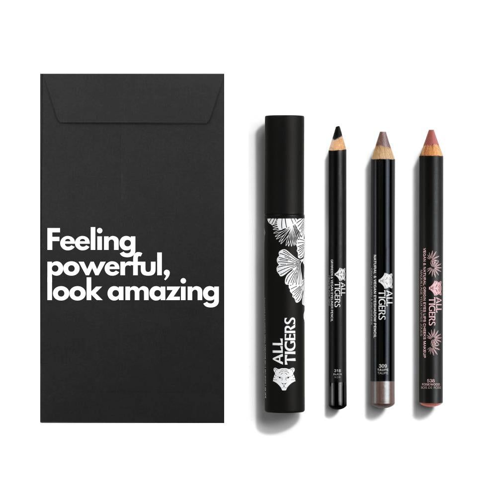 Zwarte geschenkverpakking met tekst. Daarnaast mascara, twee potloden en een lippenstift. Alle producten hebben het logo.