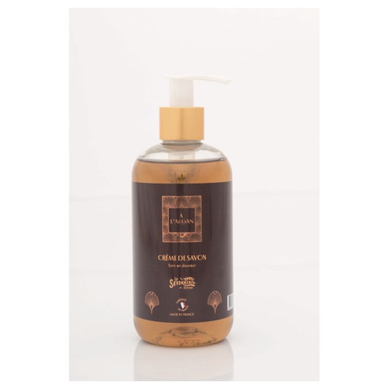 Flacon de savon liquide transparent avec étiquette marron. Avec pompe et bouchon doré. Inscription : L'Argan, Crème de Savon.