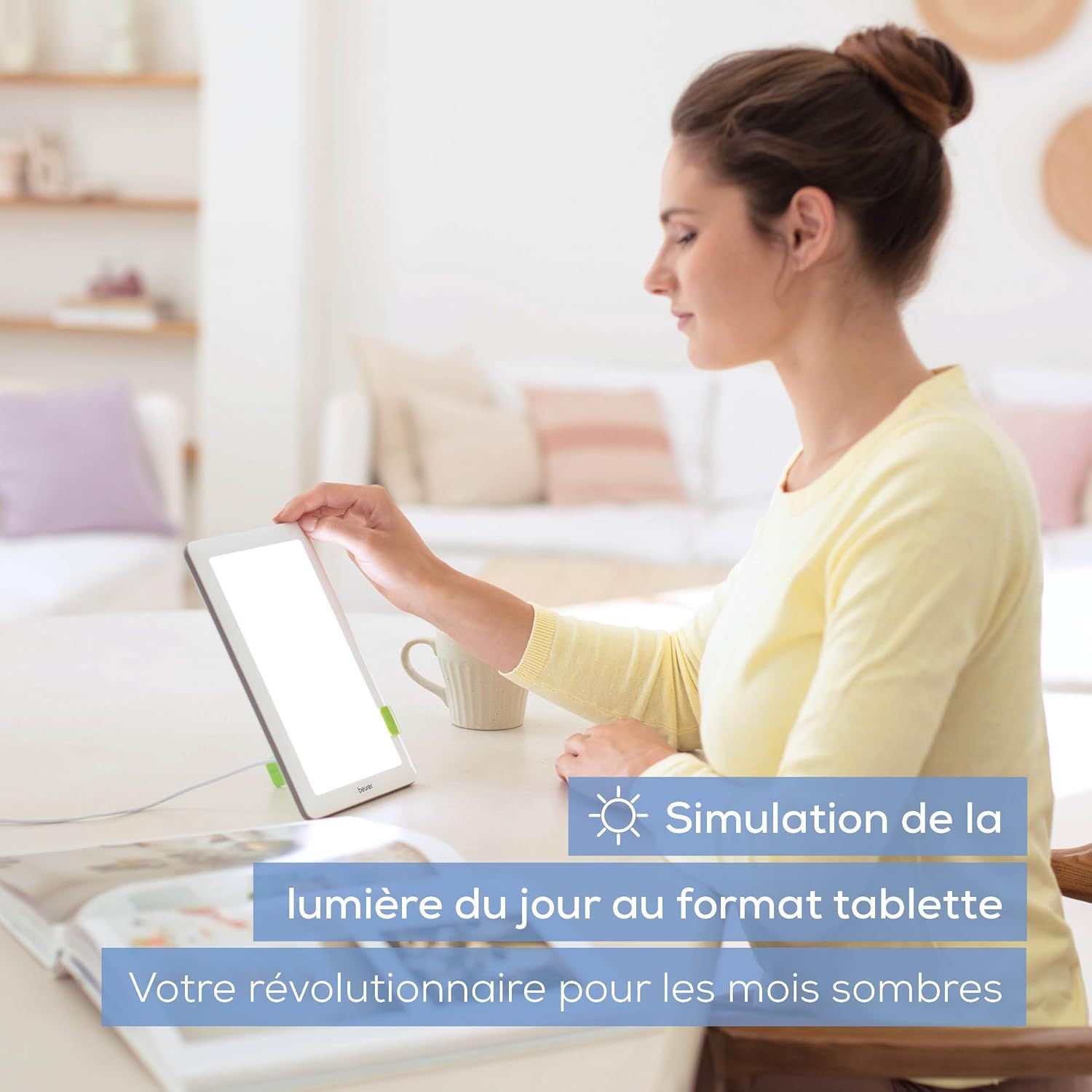 Une femme utilise un appareil de luminothérapie lumineux et rectangulaire au format tablette.