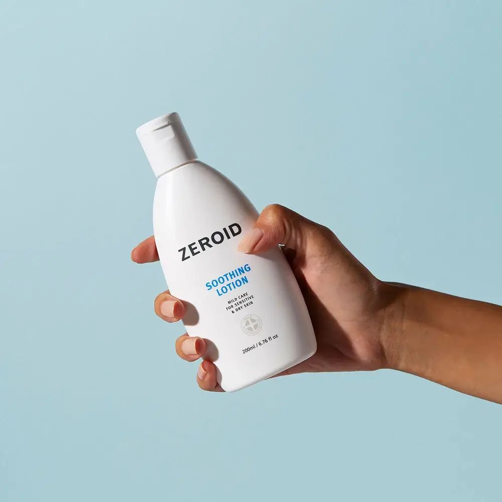 Flacon blanc ZEROID Soothing Lotion tenu en main. Logo et texte bleus. Contient 200ml/6.76 fl oz.
