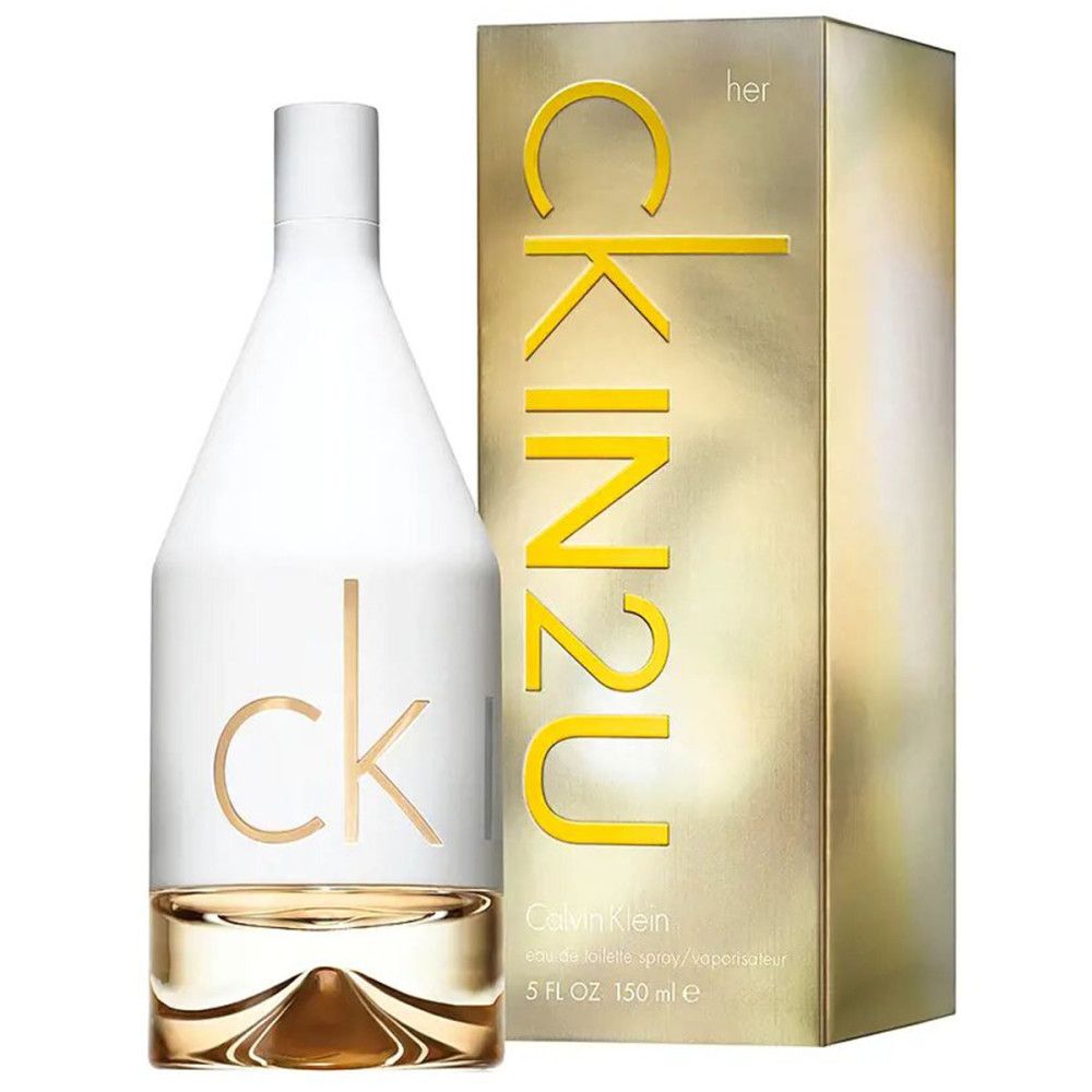 Flacon de parfum à côté d'un emballage doré avec inscription 'CK IN2U HER'.