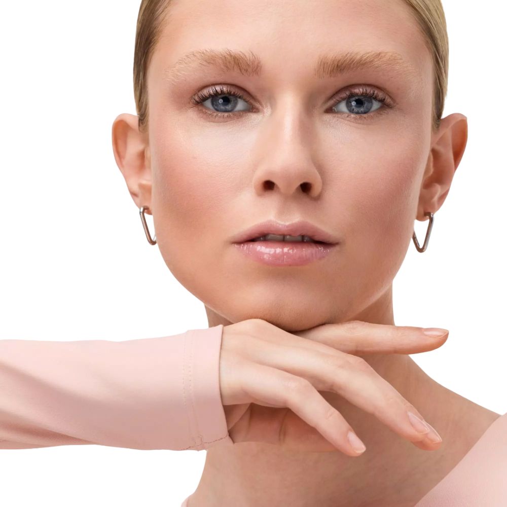 Portret van een blonde vrouw. Ze draagt zilveren oorbellen en heeft glanzende lippen.