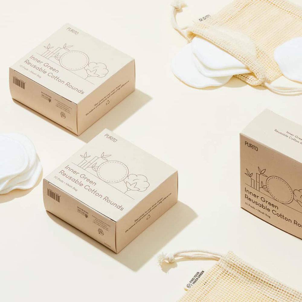 Plusieurs boîtes et sacs contenant des cotons réutilisables. Sur les boîtes, on peut lire "Inner Green Reusable Cotton Rounds".