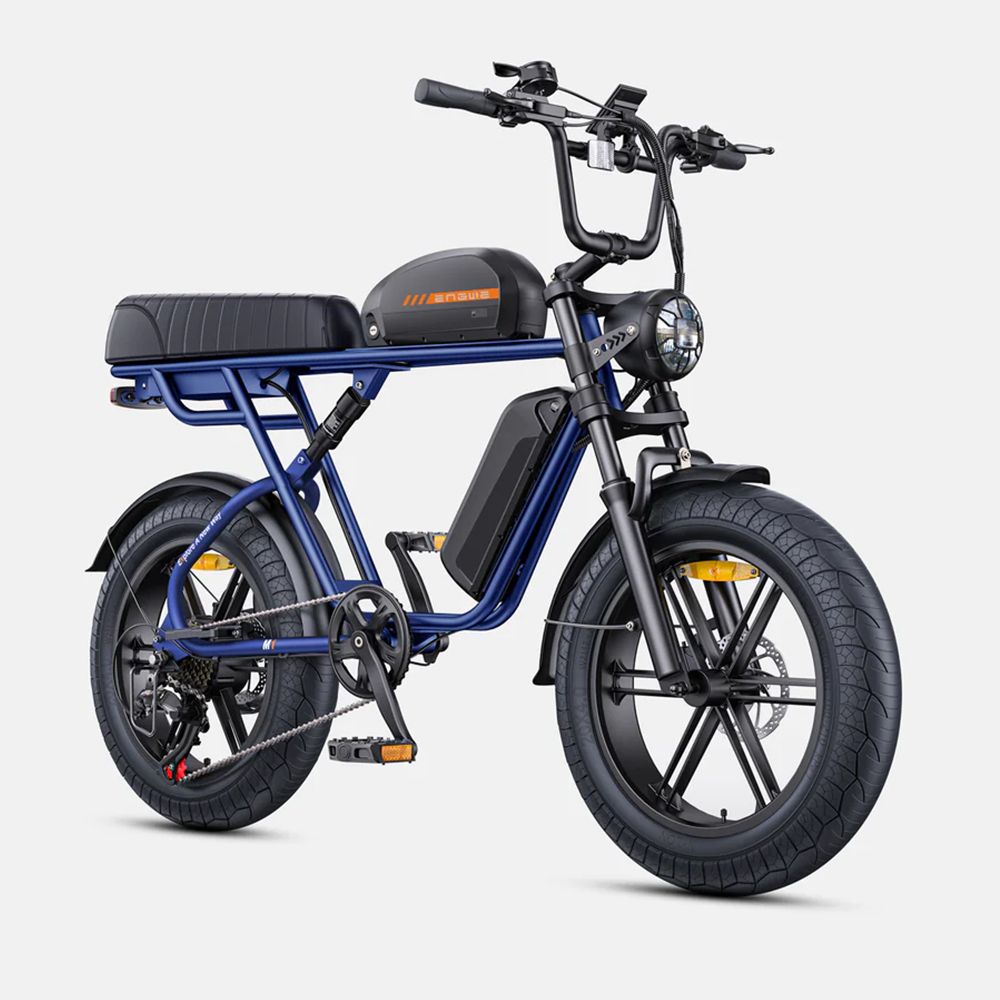 Vélo électrique bleu, pneus et selle noirs. Guidon et phare noirs. Batterie sur le cadre.