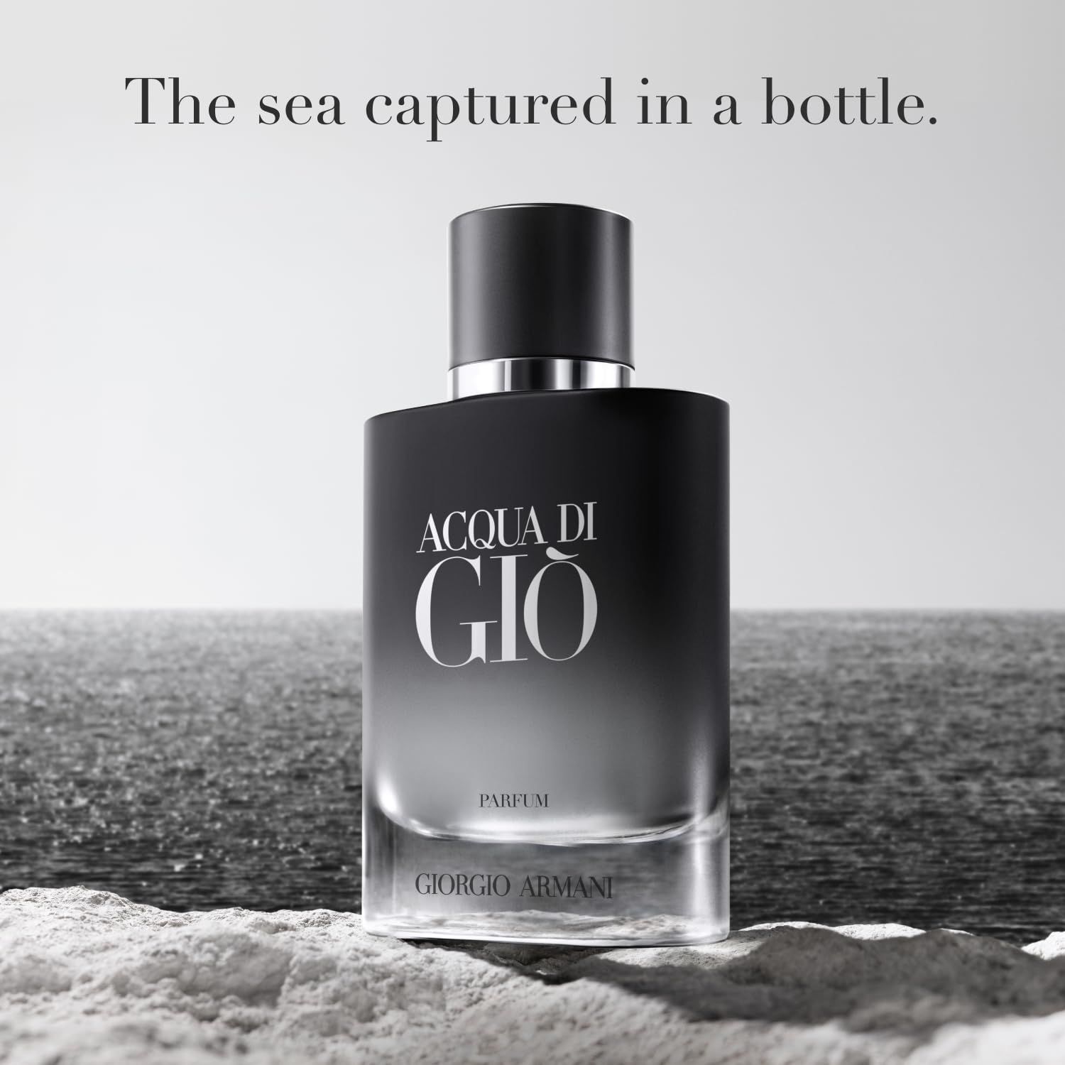 Flacon de parfum Acqua di Giò devant un fond marin. Flacon noir, inscription : Acqua di Giò, Parfum, Giorgio Armani.