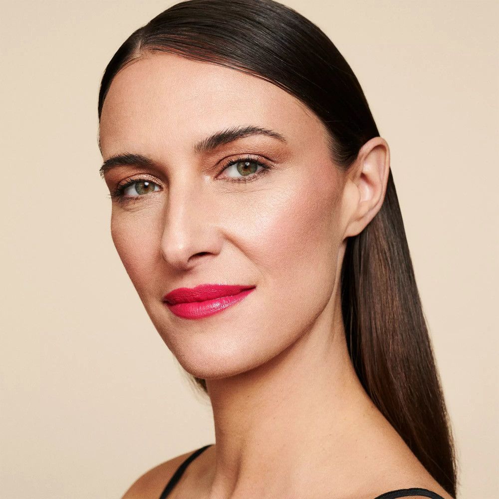 Portrait d'une femme maquillée. Rouge à lèvres rouge, peau bronzée, cheveux foncés.