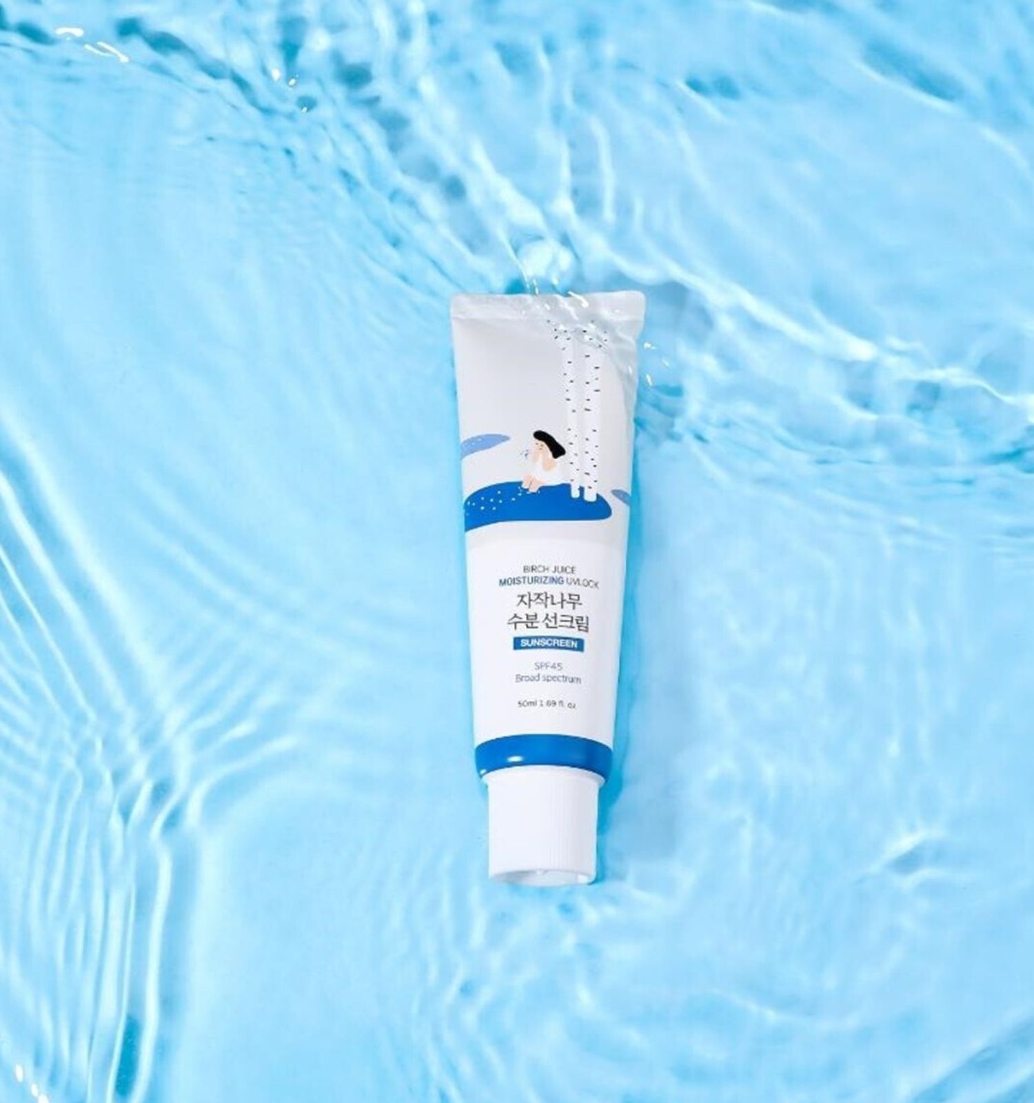 Tube avec motif de bouleau sur fond d'eau bleue. SPF 50+ PA++++.