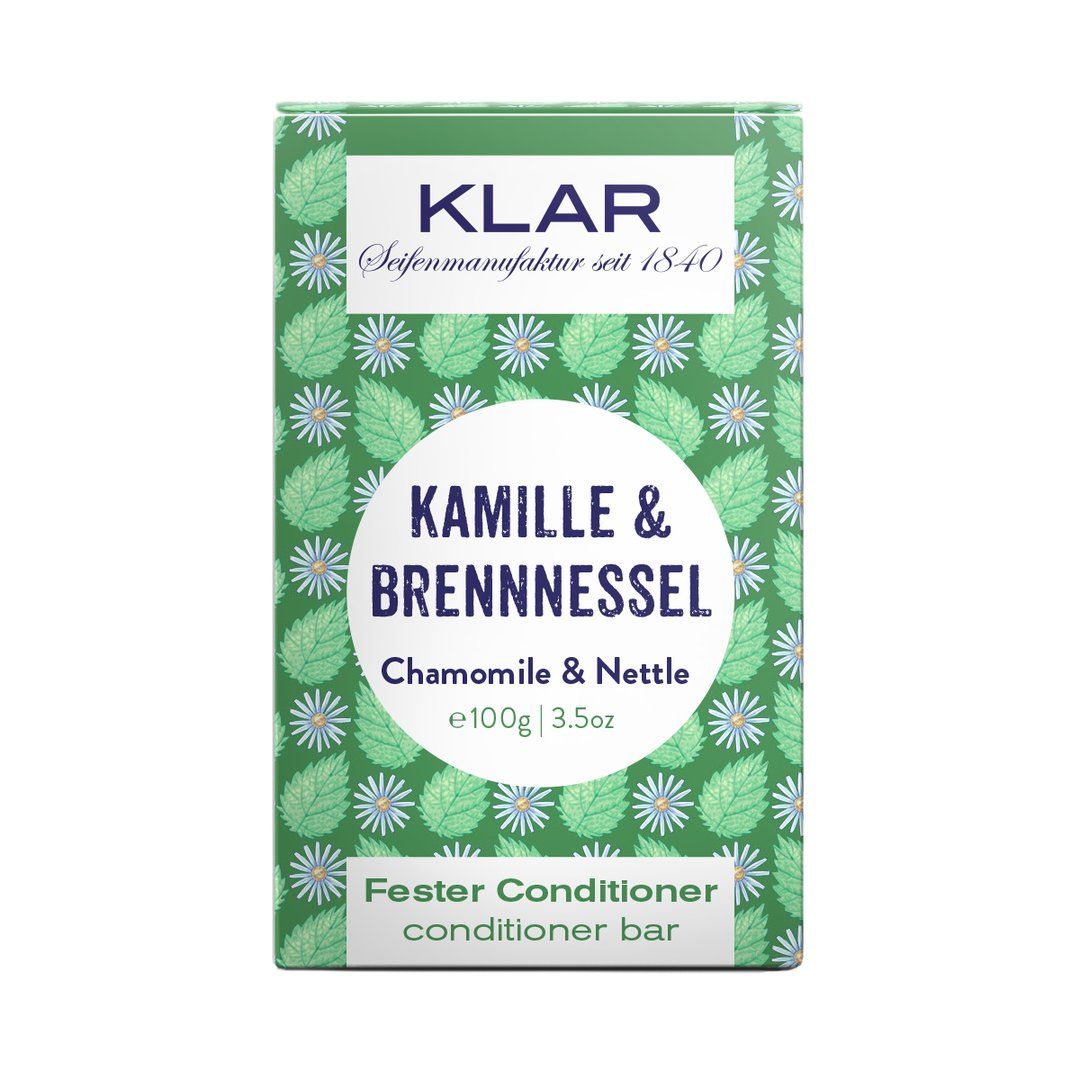 Emballage vert à motifs floraux. Texte : Klar, Camomille & Ortie, Conditionneur solide. Poids : 100g.