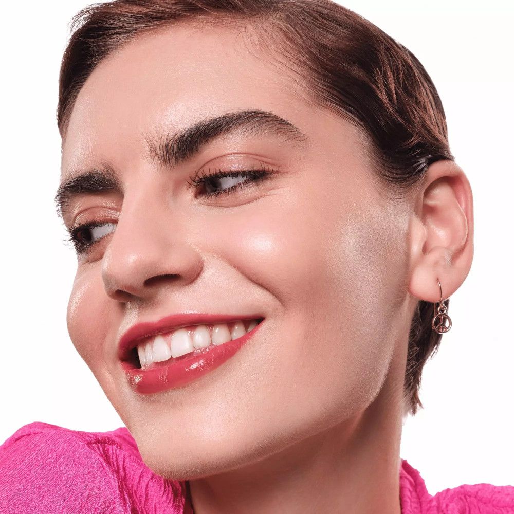 Femme avec lèvres rouges brillantes. Haut rose. Gros plan.