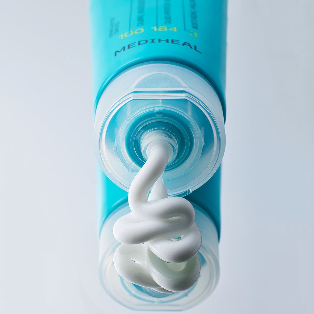 Gros plan d'un tube bleu d'où sort une crème blanche. Marque MEDIHEAL. Le bouchon est ouvert.
