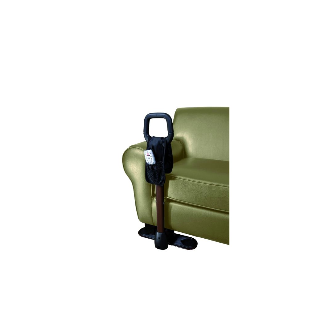 Aide au lever près d'un fauteuil vert. Poignée noire, tige marron, base noire. Avec poche et télécommande.