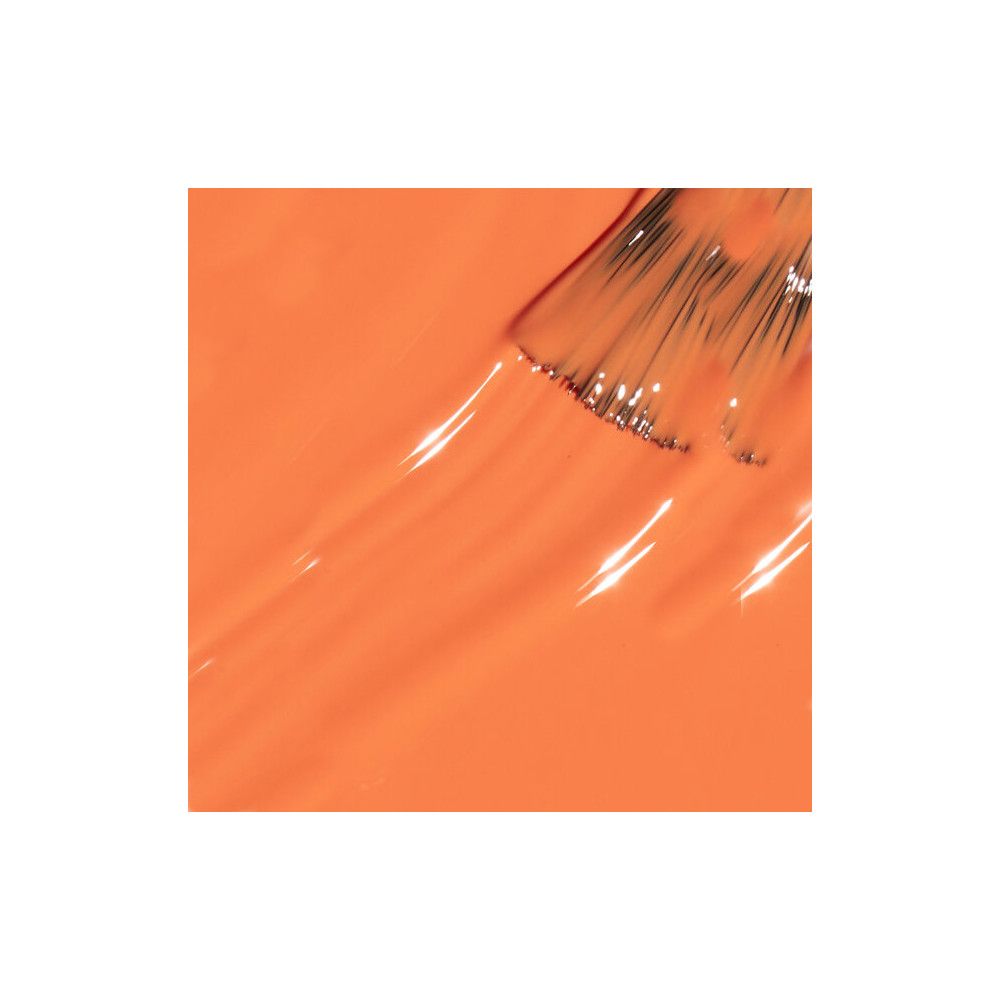 Vernis à ongles orange sur fond blanc. Pinceau touchant la surface. Texture brillante.