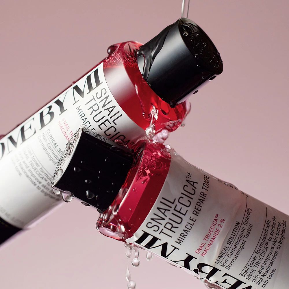 Deux bouteilles rouges d'où s'égoutte du liquide. Les bouteilles portent l'inscription SOME BY MI et Snail TrueCICA Miracle Repair Toner.