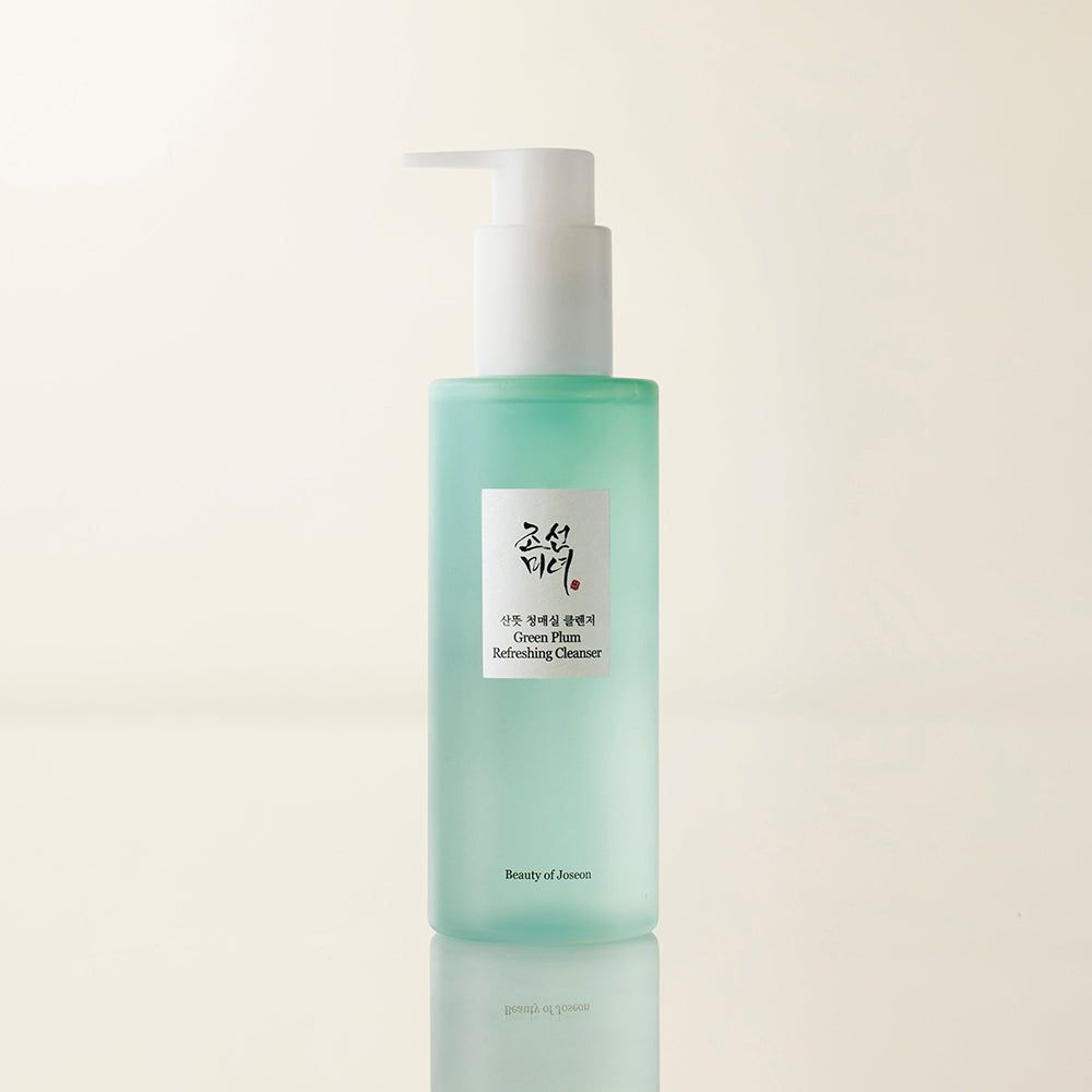 Flacon pompe vert étiqueté 'Green Plum Refreshing Cleanser'.
