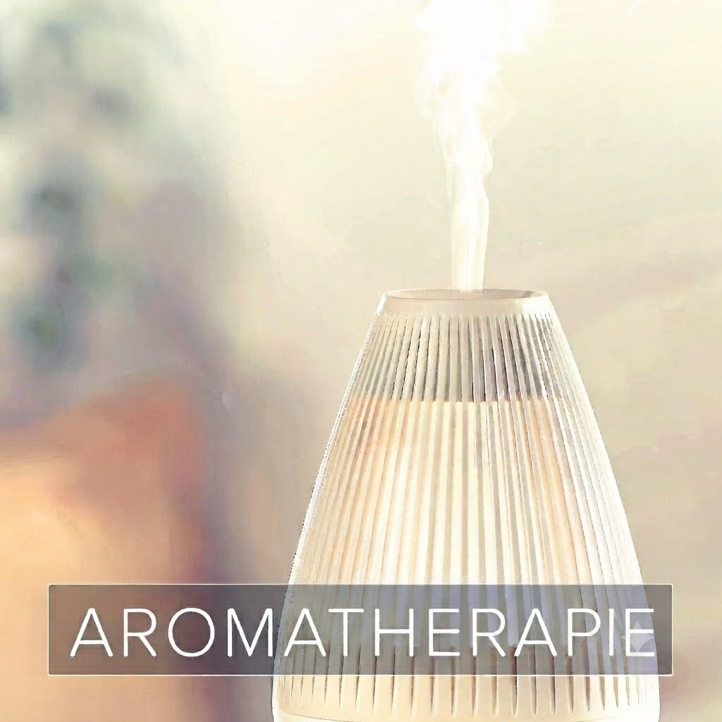 Een witte diffuser met geribd oppervlak geeft stoom af. "AROMATHERAPIE" is onderaan afgedrukt.