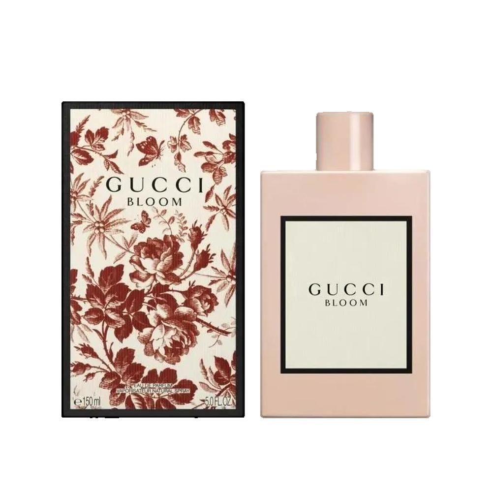Roze fles en doos. Opschrift Gucci Bloom. Doos met bloemenpatroon. Fles met wit etiket en zwarte lijst.
