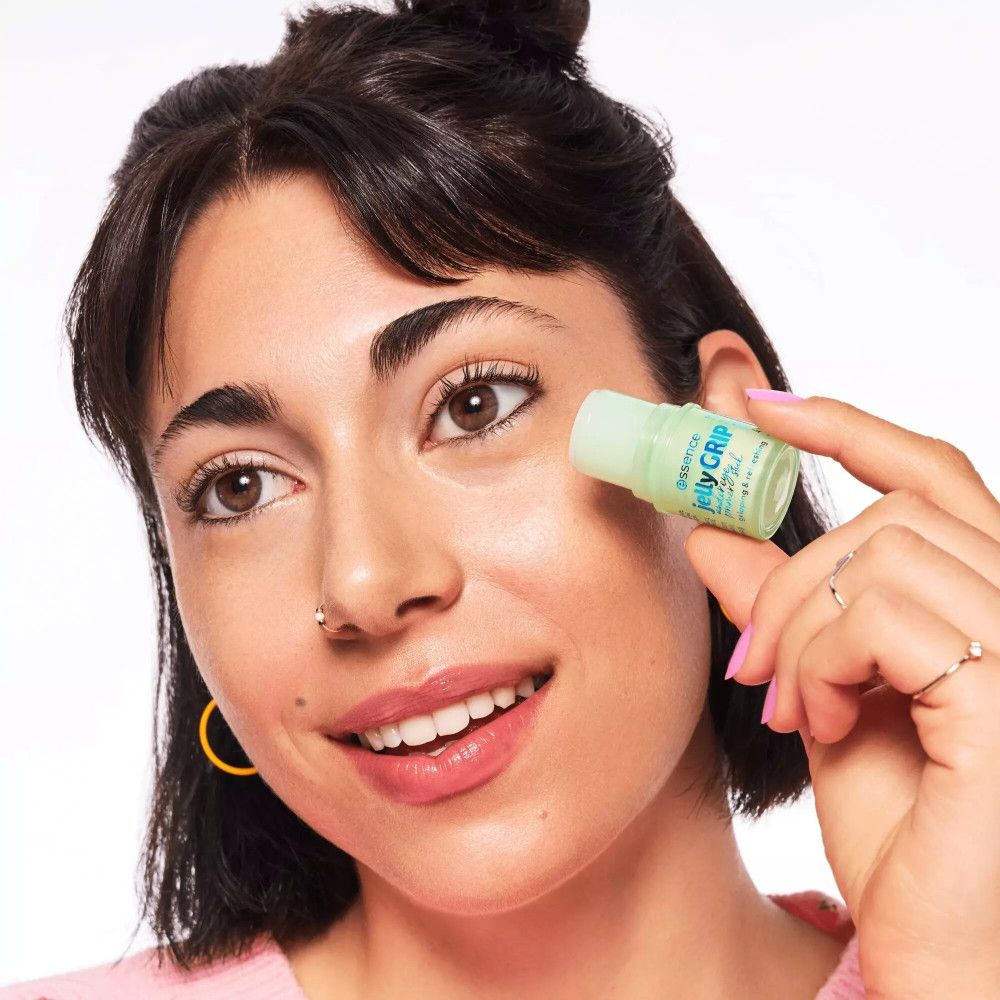 Vrouw houdt groene primer stick bij haar oog. Opschrift: essence jelly GRIP under eye primer stick.