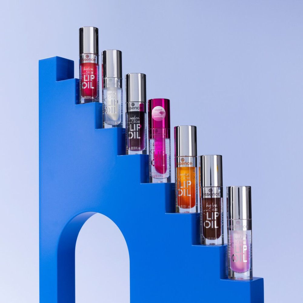 Meerdere lipgloss flesjes op een blauwe trap. Verschillende kleuren zijn zichtbaar.