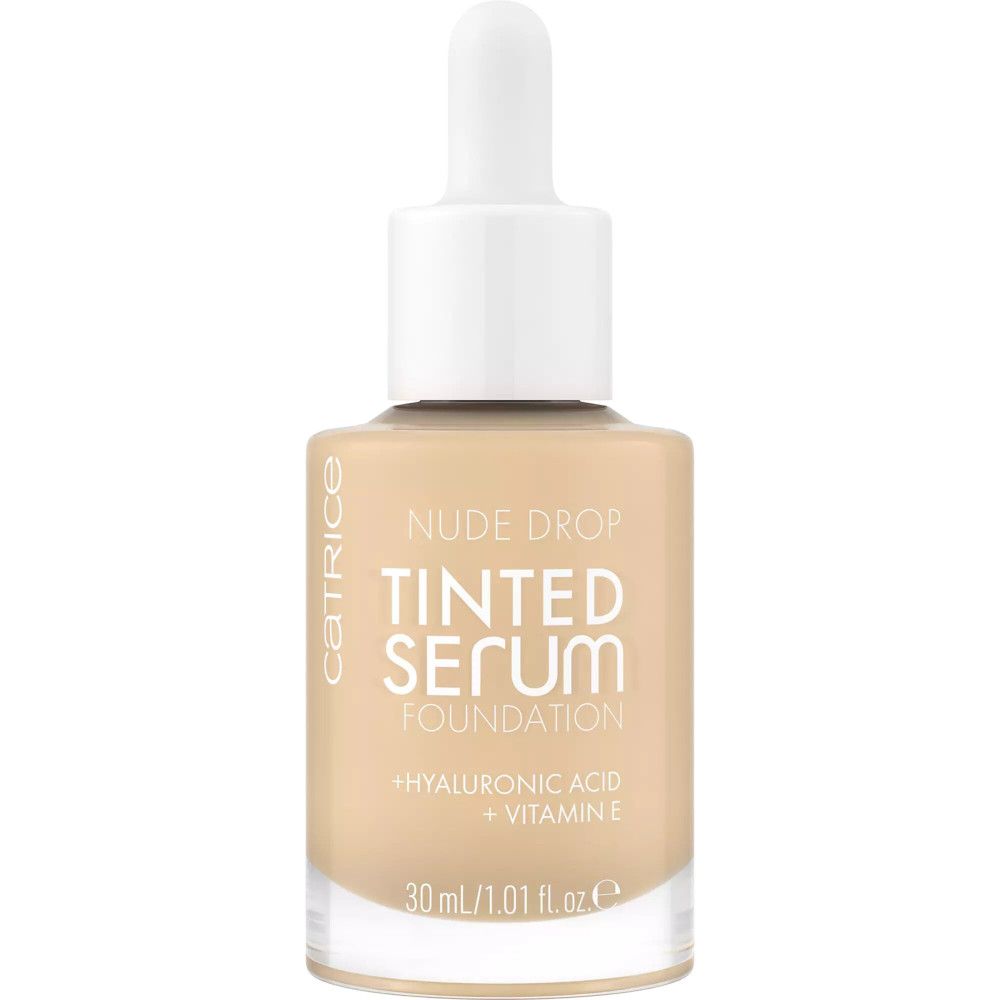 Flacon de sérum teinté. Inscription : Nude Drop, Tinted Serum Foundation, Acide hyaluronique + Vitamine E. 30 ml/1.01 fl. oz.
