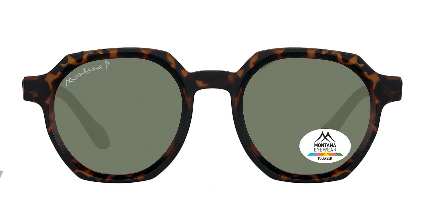 Zonnebril met bruin montuur en groene glazen. Een sticker met het Montana Eyewear logo is zichtbaar op een glas.