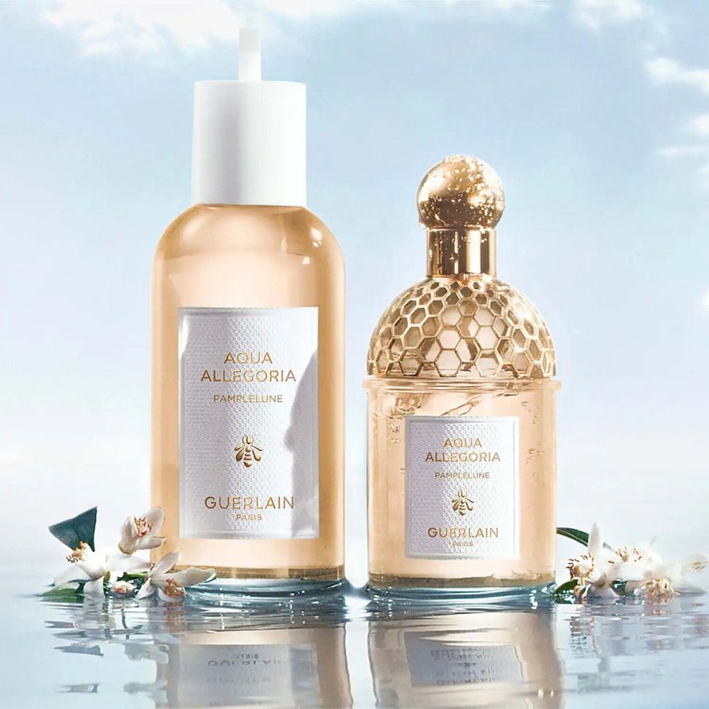 Deux flacons de parfum. Inscription: Aqua Allegoria Pamplelune, Guerlain Paris. Fond: eau et fleurs.