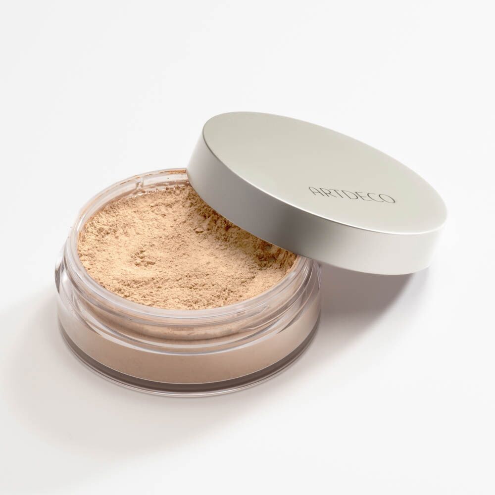 Pot de poudre libre ouvert. Couvercle argenté avec ARTDECO. Poudre beige clair.