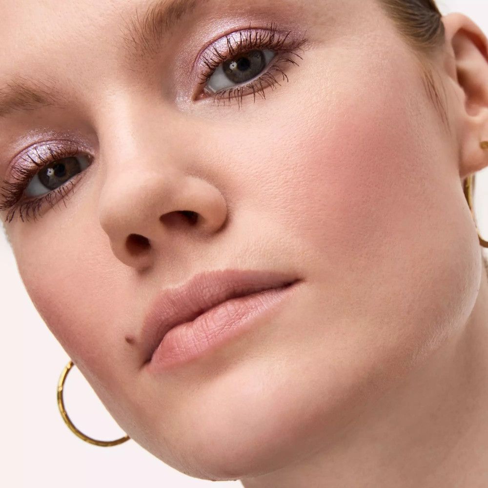 Gros plan d'un visage avec les yeux maquillés. Fard à paupières rose. Teint rose.