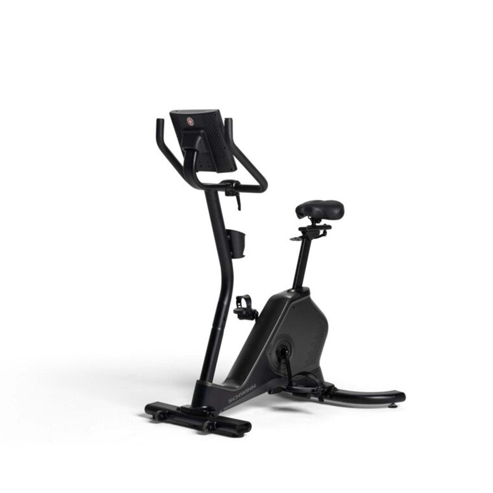 Vélo d'appartement noir. Console, guidon, siège et pédales visibles. Logo Schwinn sur la console.