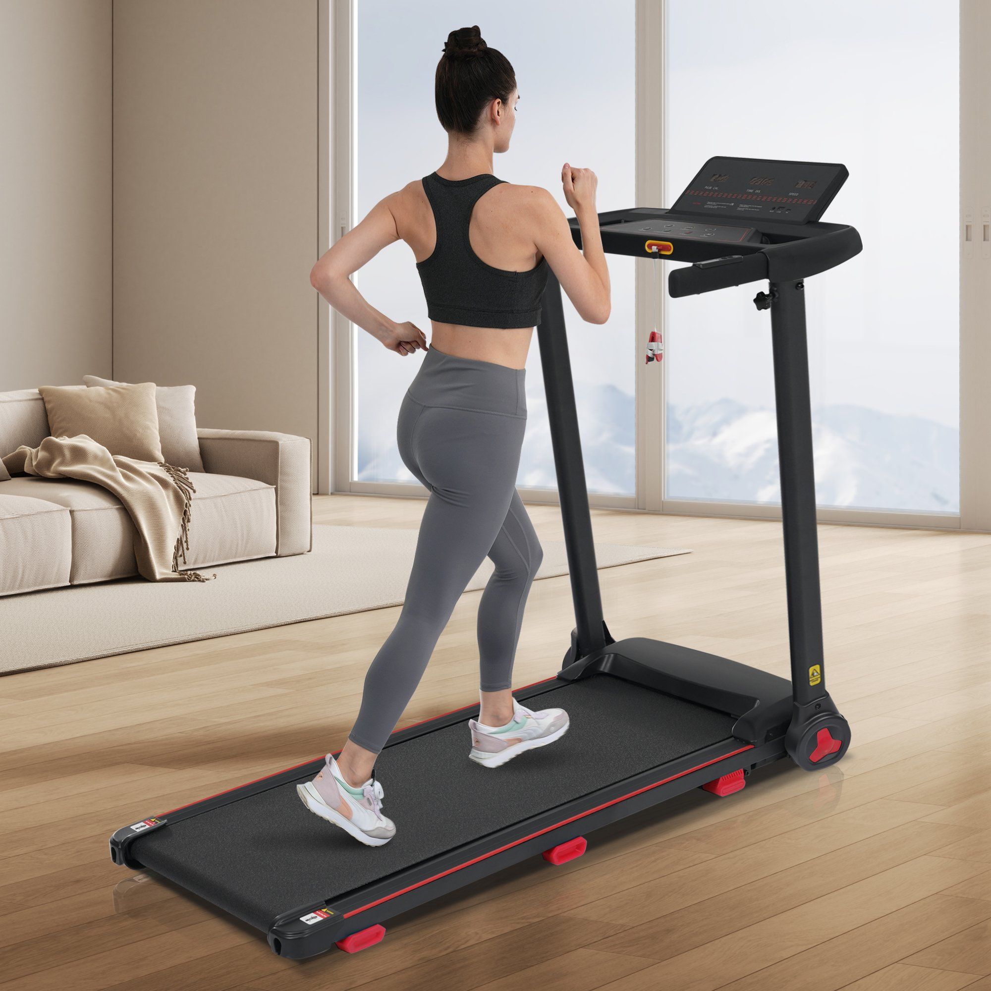 Tapis roulant pliable noir avec accent rouge, vu de côté par une femme.