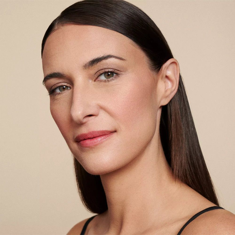 Portrait d'une femme aux longs cheveux foncés. Elle porte un haut noir. Maquillage discret.