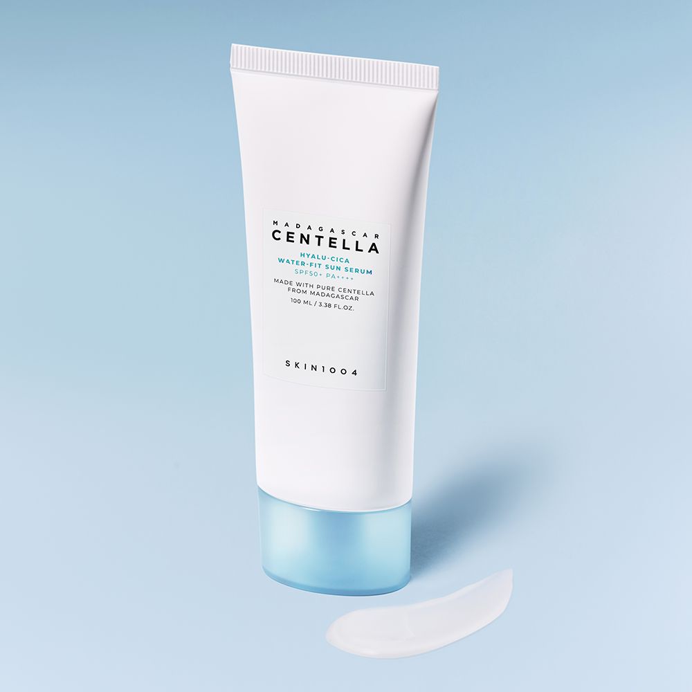 Witte tube met crème ernaast. Opschrift: MADAGASCAR CENTELLA HYALU-CICA WATER-FIT SUN SERUM. Merk SKIN1004.