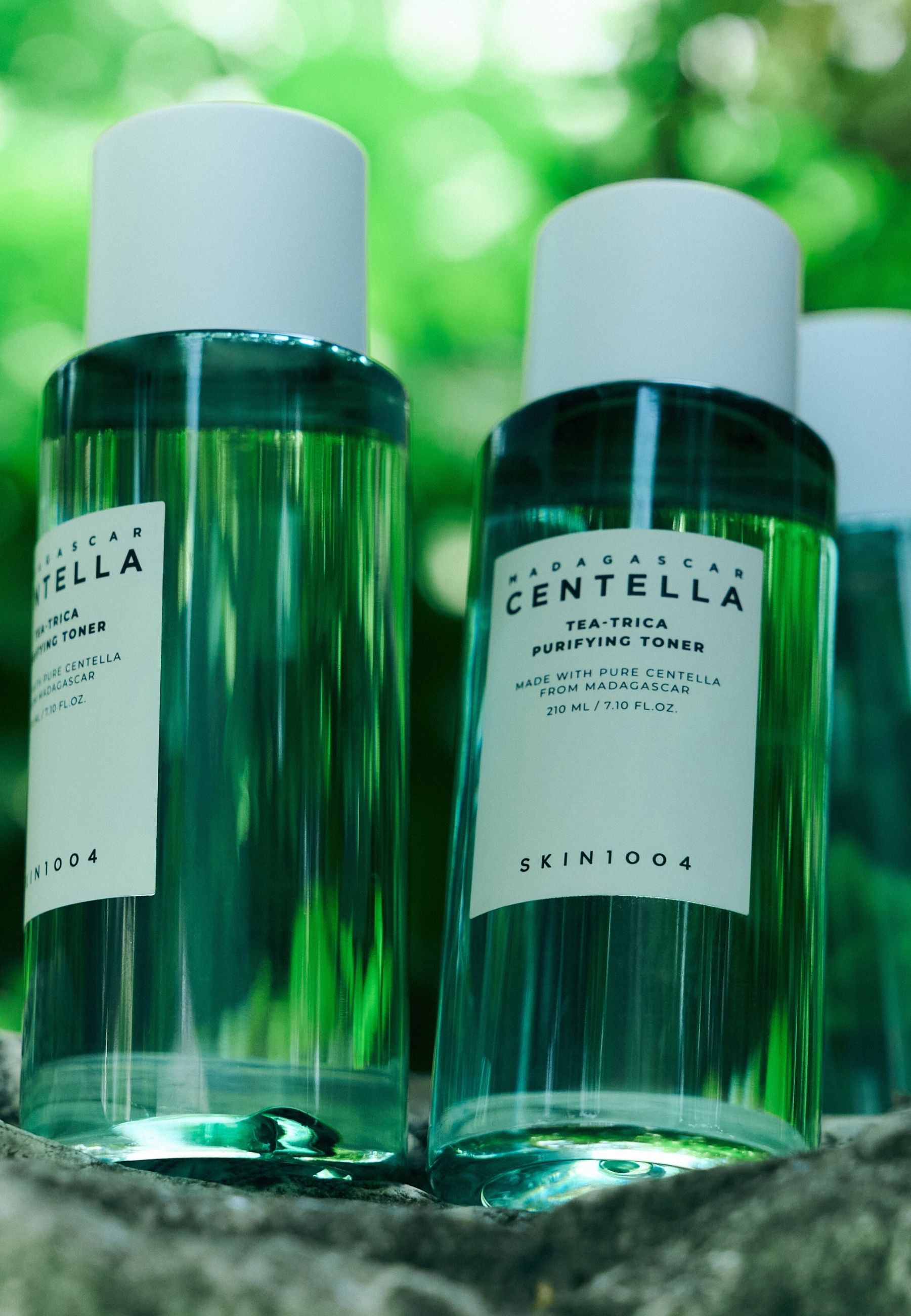 Meerdere groene flessen met witte dop. Label: MADAGASCAR CENTELLA TEA-TRICA. Merk SKIN1004.