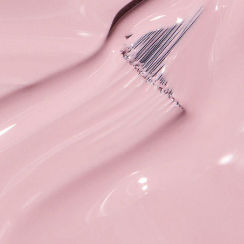 Vernis à ongles rose avec pinceau. Gros plan, texture brillante.