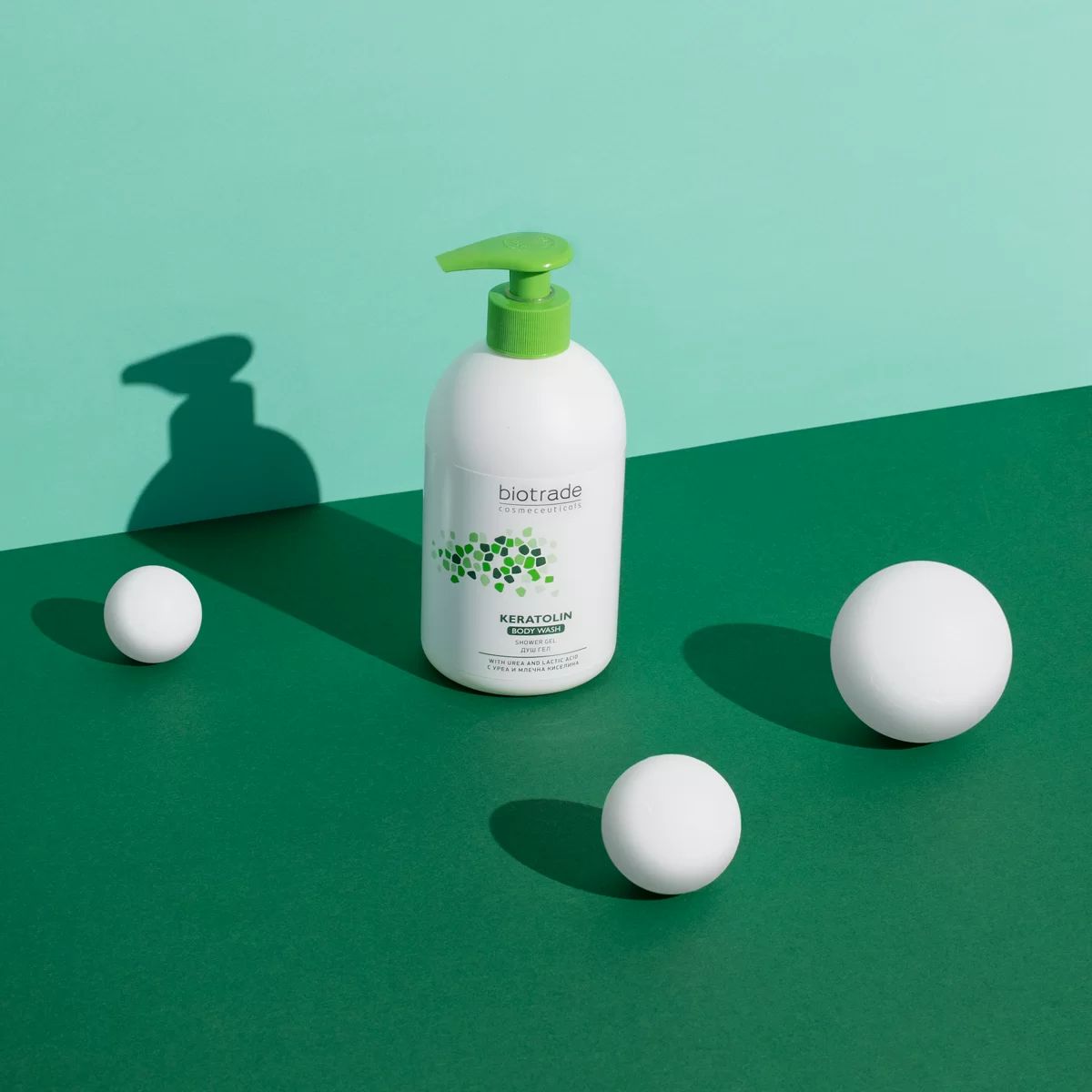 Flacon blanc avec pompe verte. Inscription Biotrade et Keratolin. Trois boules blanches sur fond vert.
