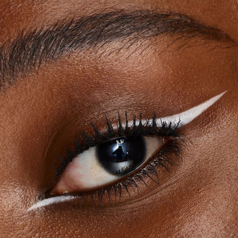 Gros plan sur un œil avec trait de khôl blanc sur la paupière supérieure.