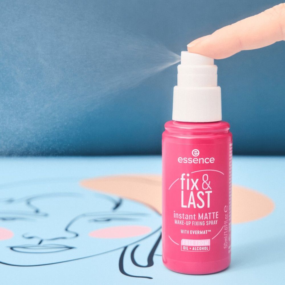 Roze fixatiespray, nevel zichtbaar. Opschrift: fix & LAST, instant MATTE. Merk: essence. Witte sproeikop.