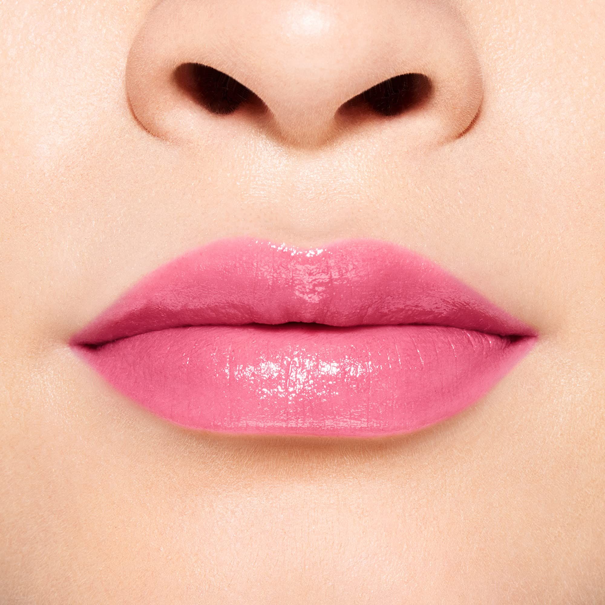 Gros plan sur des lèvres recouvertes de baume à lèvres rose. Les lèvres sont brillantes.