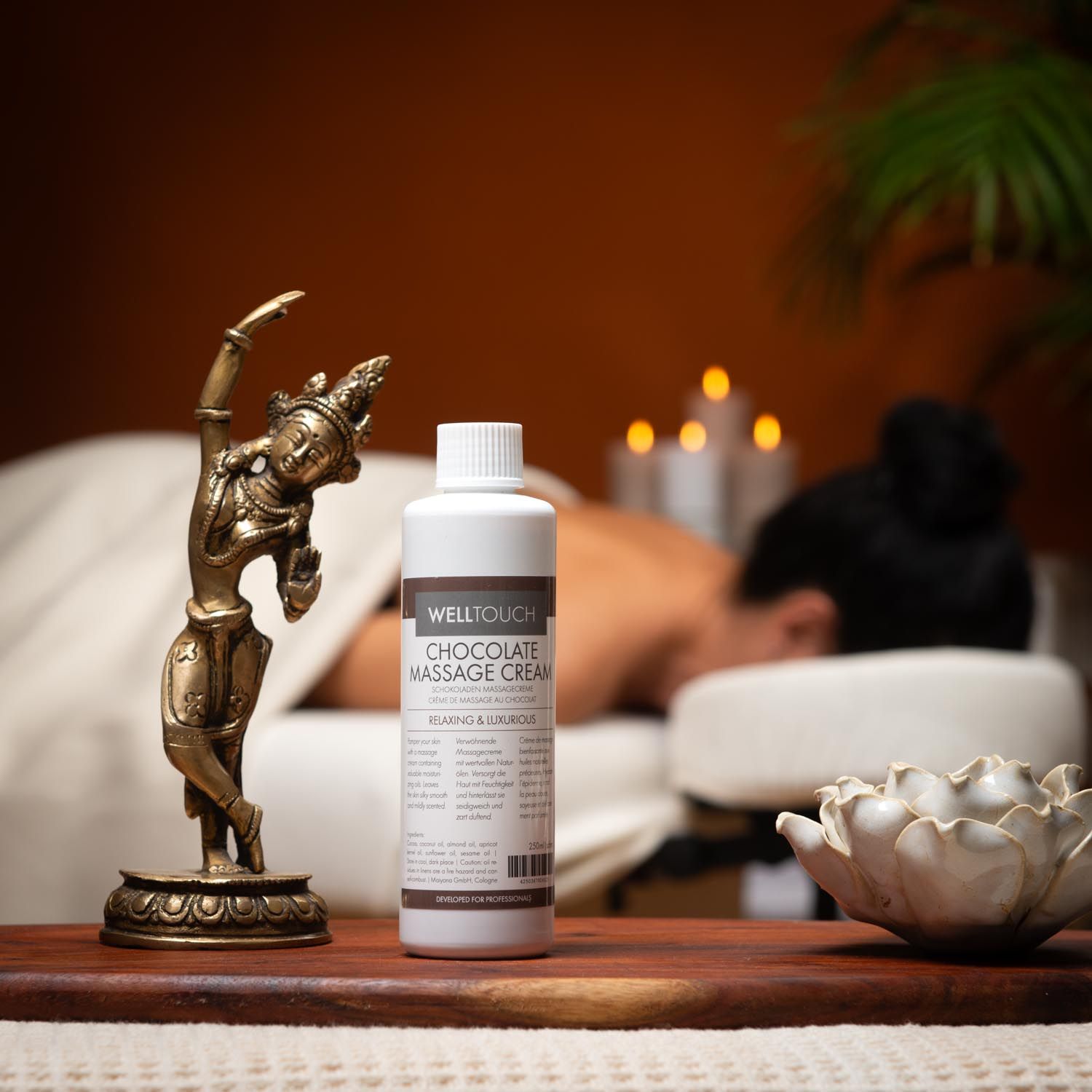 Witte fles Welltouch Chocolate Massage Cream. Opschrift: Chocolate Massage Cream. Bruine dop, wit etiket.