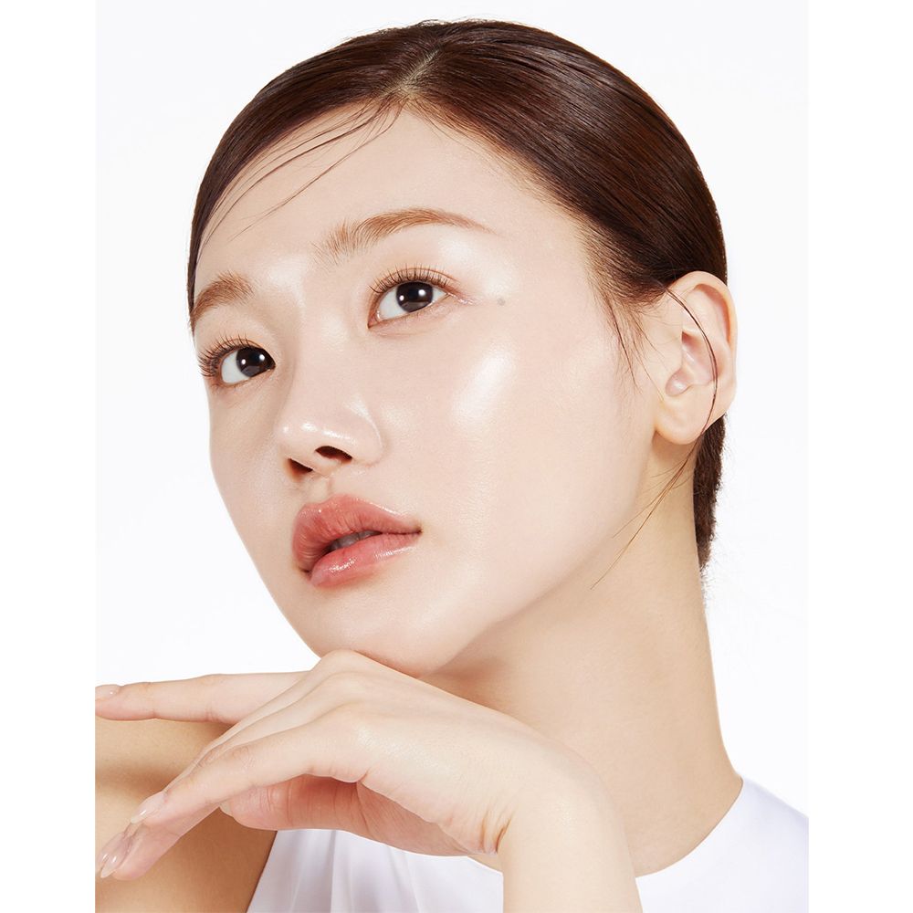 Femme avec peau brillante. Flacon de sérum rose avec embout compte-gouttes. Texte : medicube, Collagen Glow Booster Milk Serum.