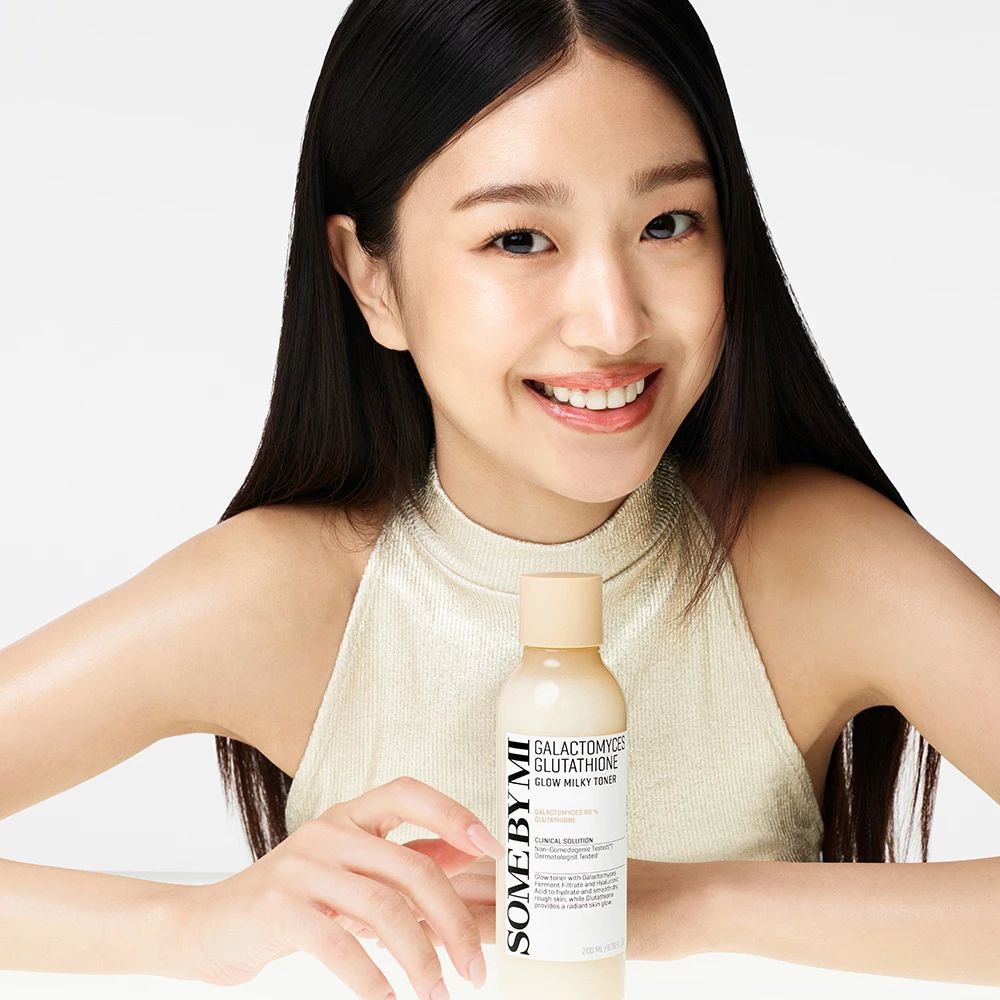 Vrouw houdt fles SOME BY MI, Galactomyces Glutathione Glow Milky Toner vast. Vrouw lacht.