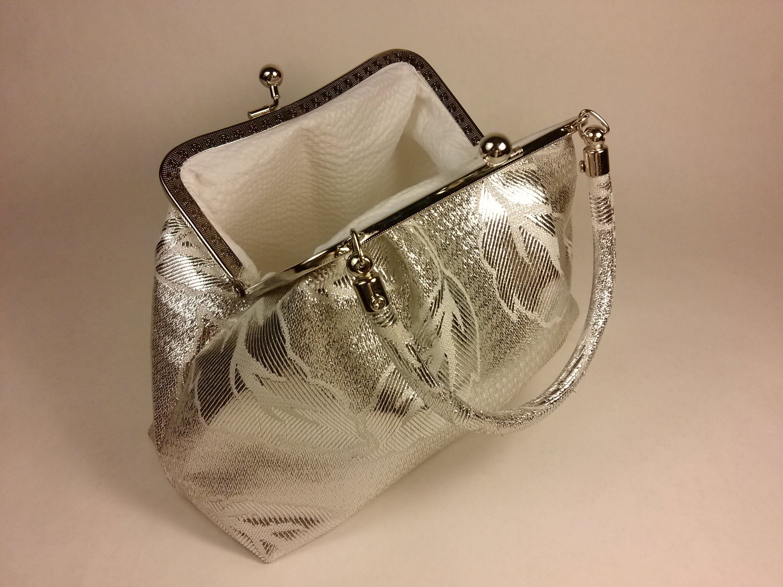 Sac argenté à motifs floraux. Ouvert, avec poignée.