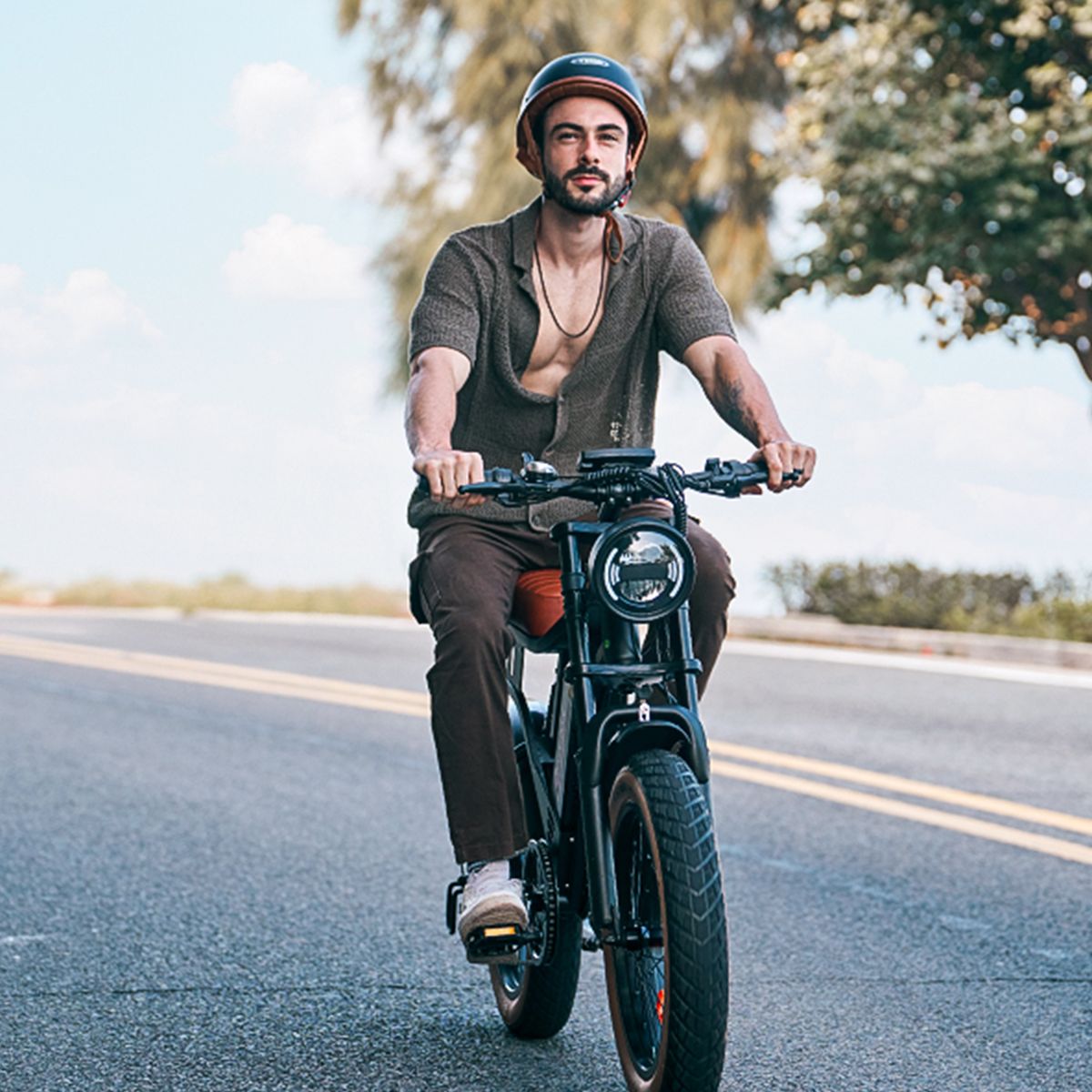 Man op een zwarte elektrische fiets. Hij draagt een helm en een overhemd.