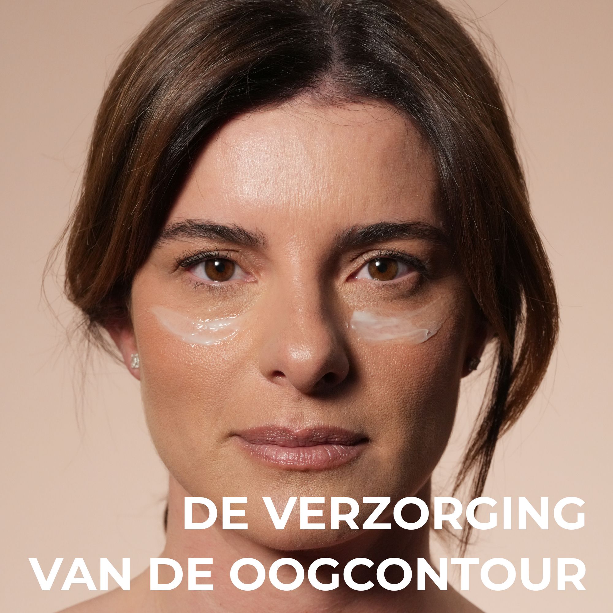 Vrouw met oogcrème op de huid onder de ogen.