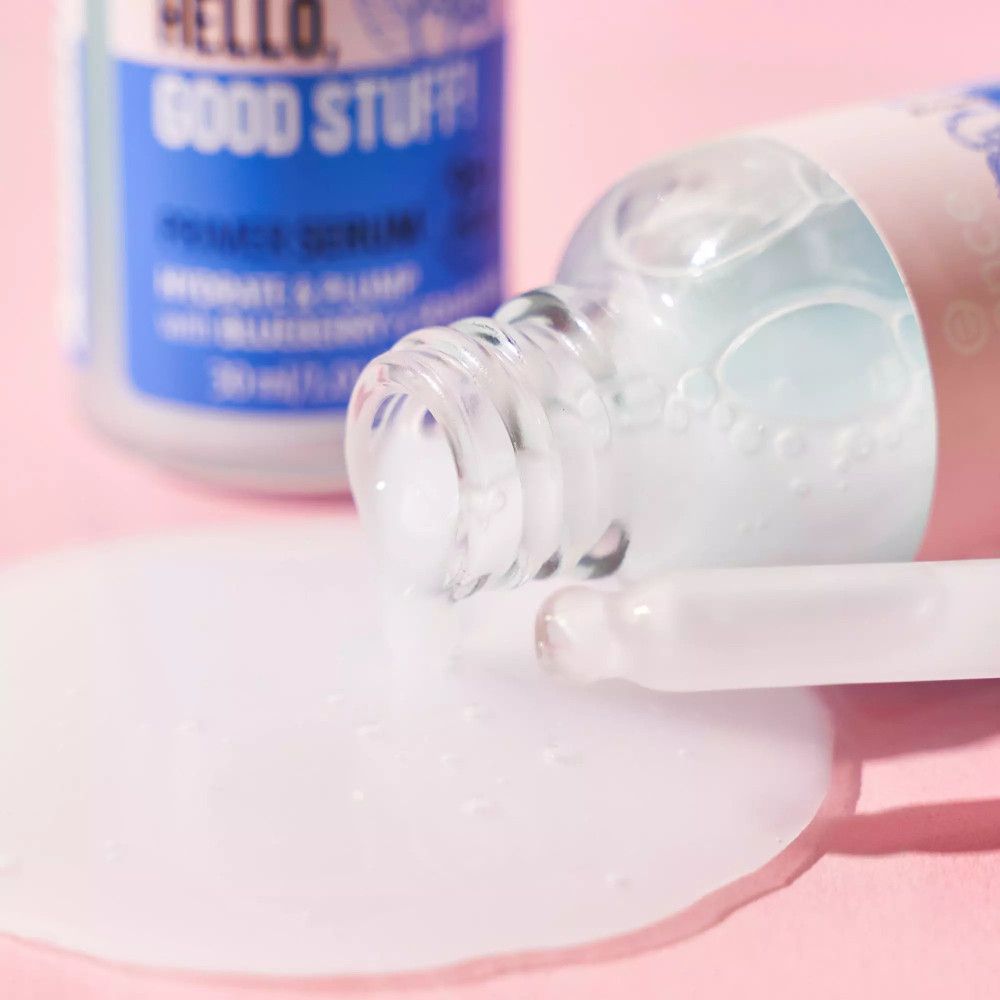 Serumflesje op een roze oppervlak. Daarnaast een plasje serum en een pipet.