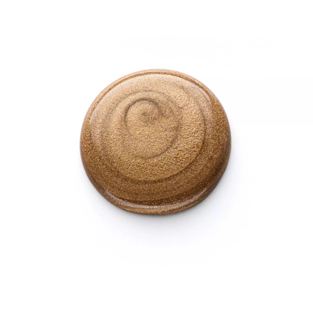 Goutte de vernis à ongles doré. Forme ronde avec texture en spirale. Sur fond blanc.