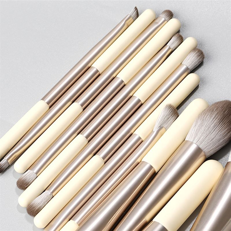 Ensemble de pinceaux de maquillage. 12 pinceaux avec manches crème, viroles argentées et différentes têtes.