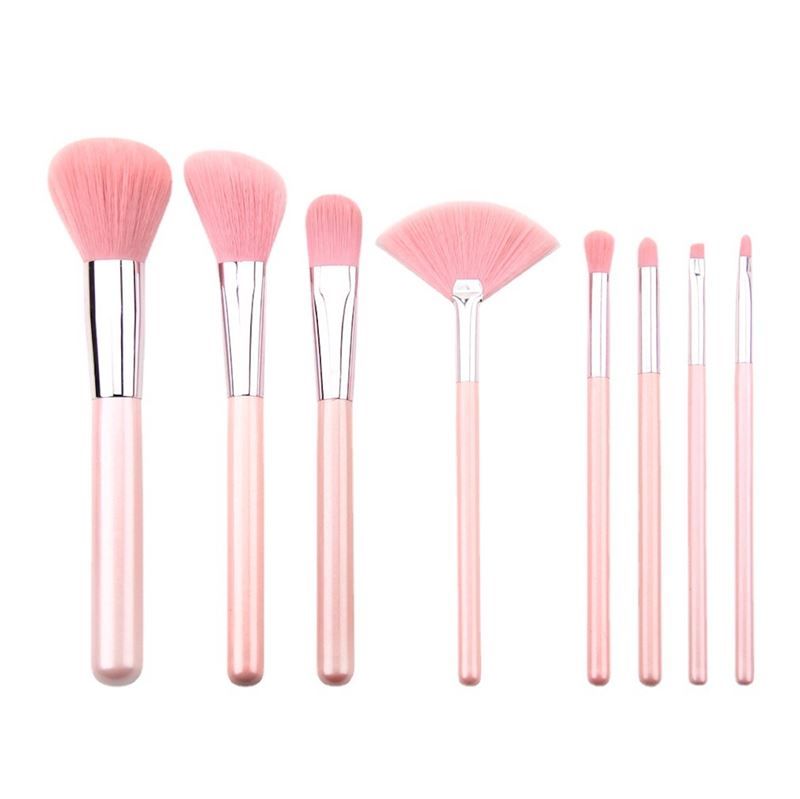 Een set van acht roze make-upkwasten met zilveren accenten, op een witte achtergrond.