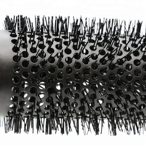 Vue détaillée d'une brosse ronde avec poils et fût perforé en céramique.