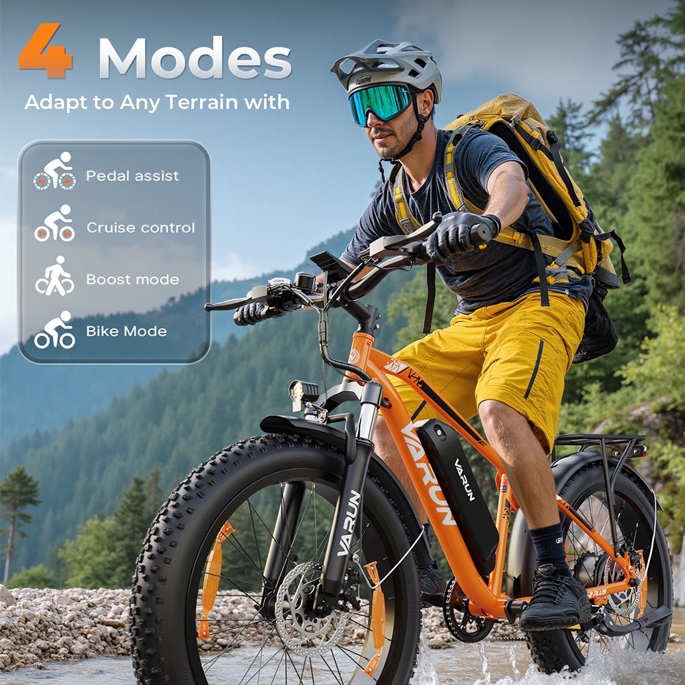 Man fietst op een oranje VARUN e-mountainbike door een beek. 4 rijmodi. Helm, rugzak, bril.